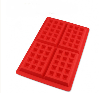 a red silicone waffle maker with squares on it