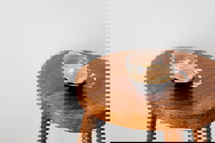 a cup of coffee is sitting on a wooden stool