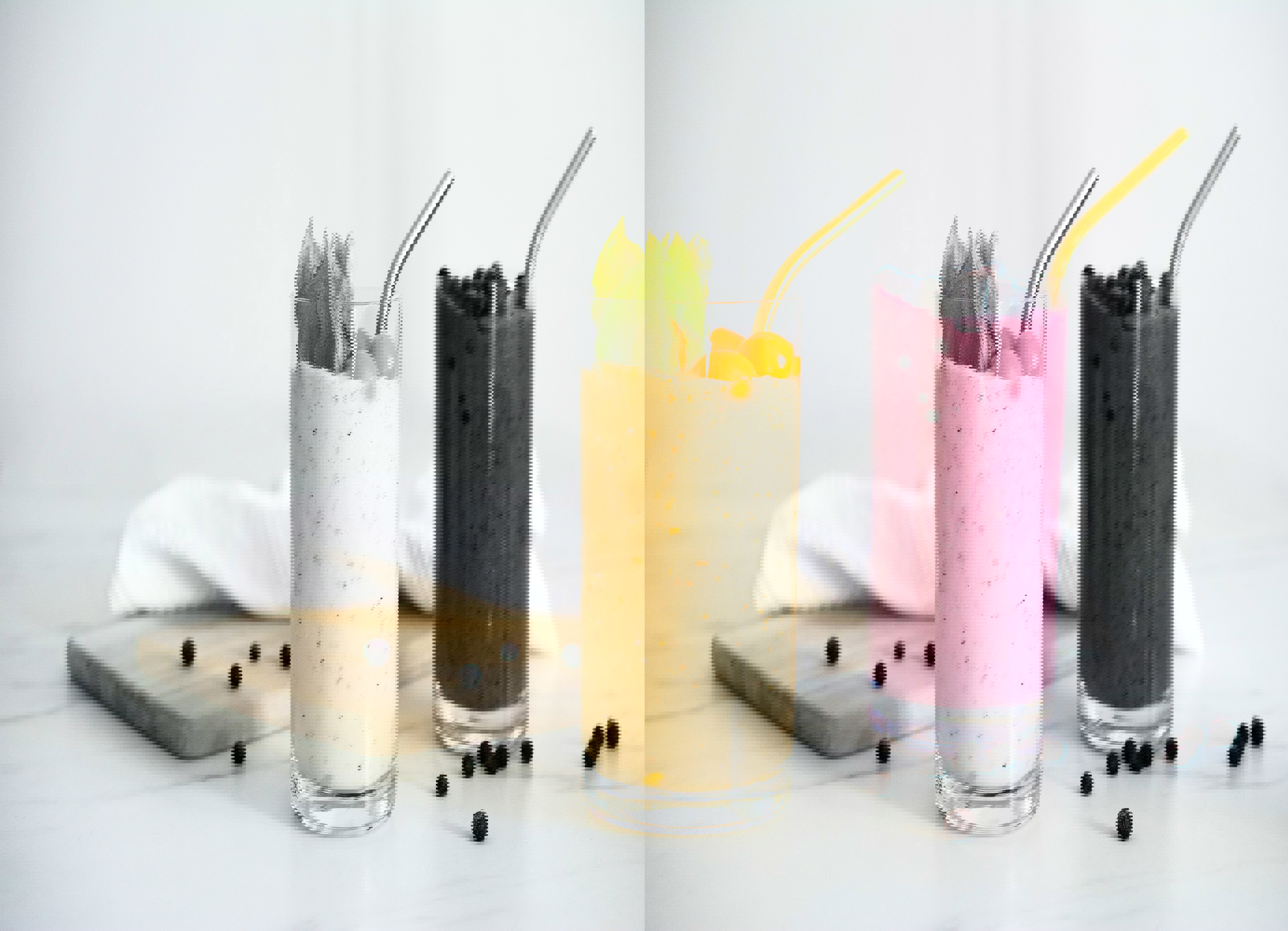 two smoothies in tall glasses with gold straws on a table