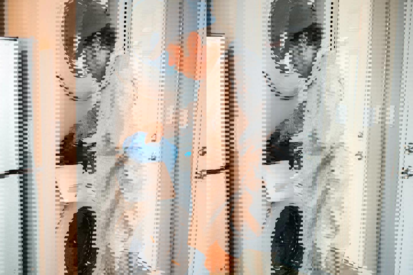 a man is pouring water into a washer and dryer