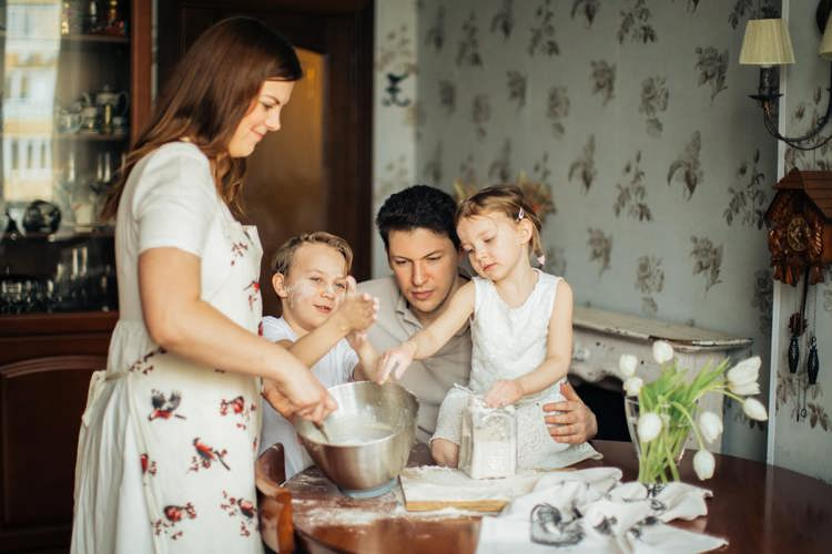 a family is preparing food together in the kitchen