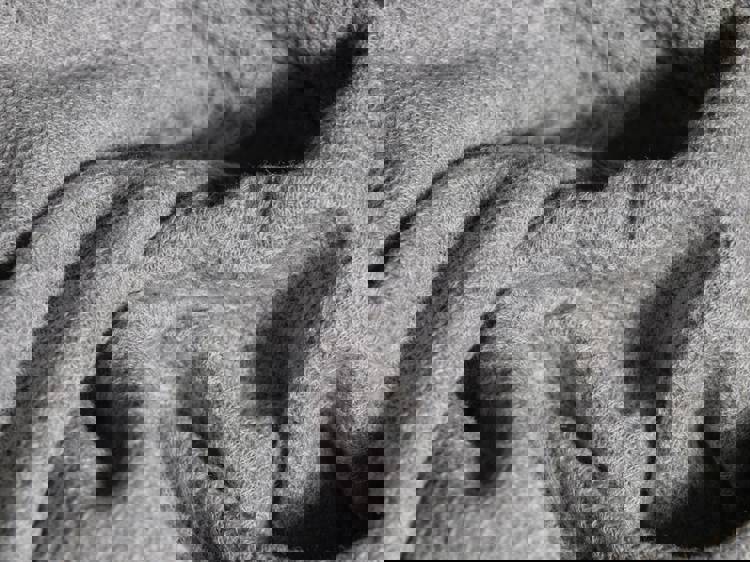 a close up of a gray blanket with a pattern on it