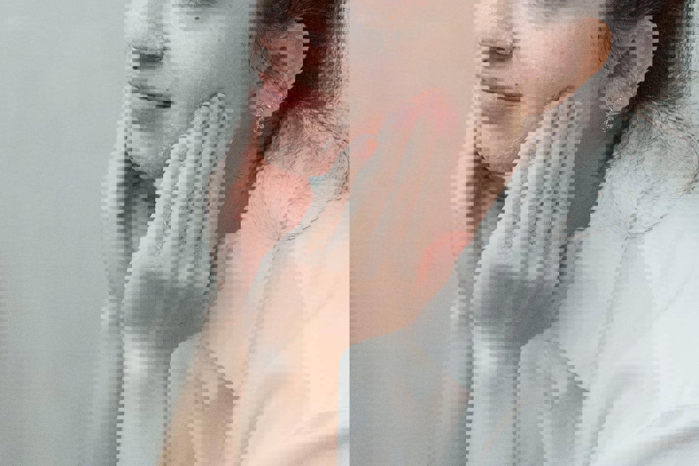 a woman is washing her face with soap and water