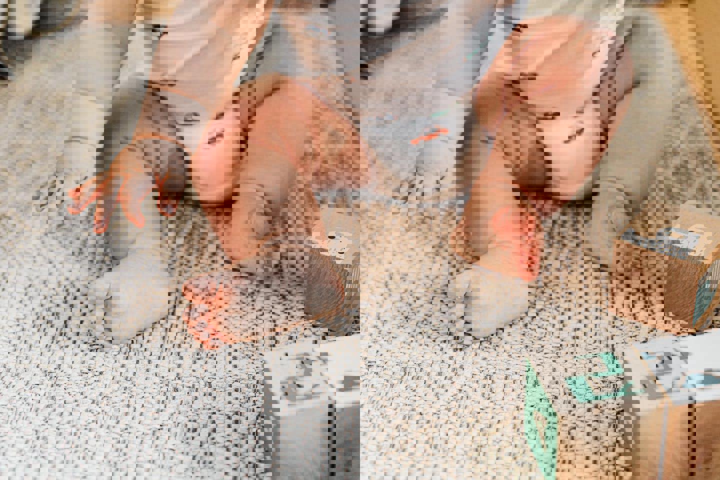 a baby is sitting on a rug next to wooden blocks with the letter f on them