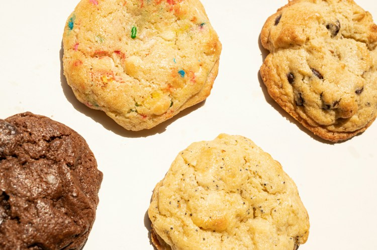 four different types of cookies are on a white surface