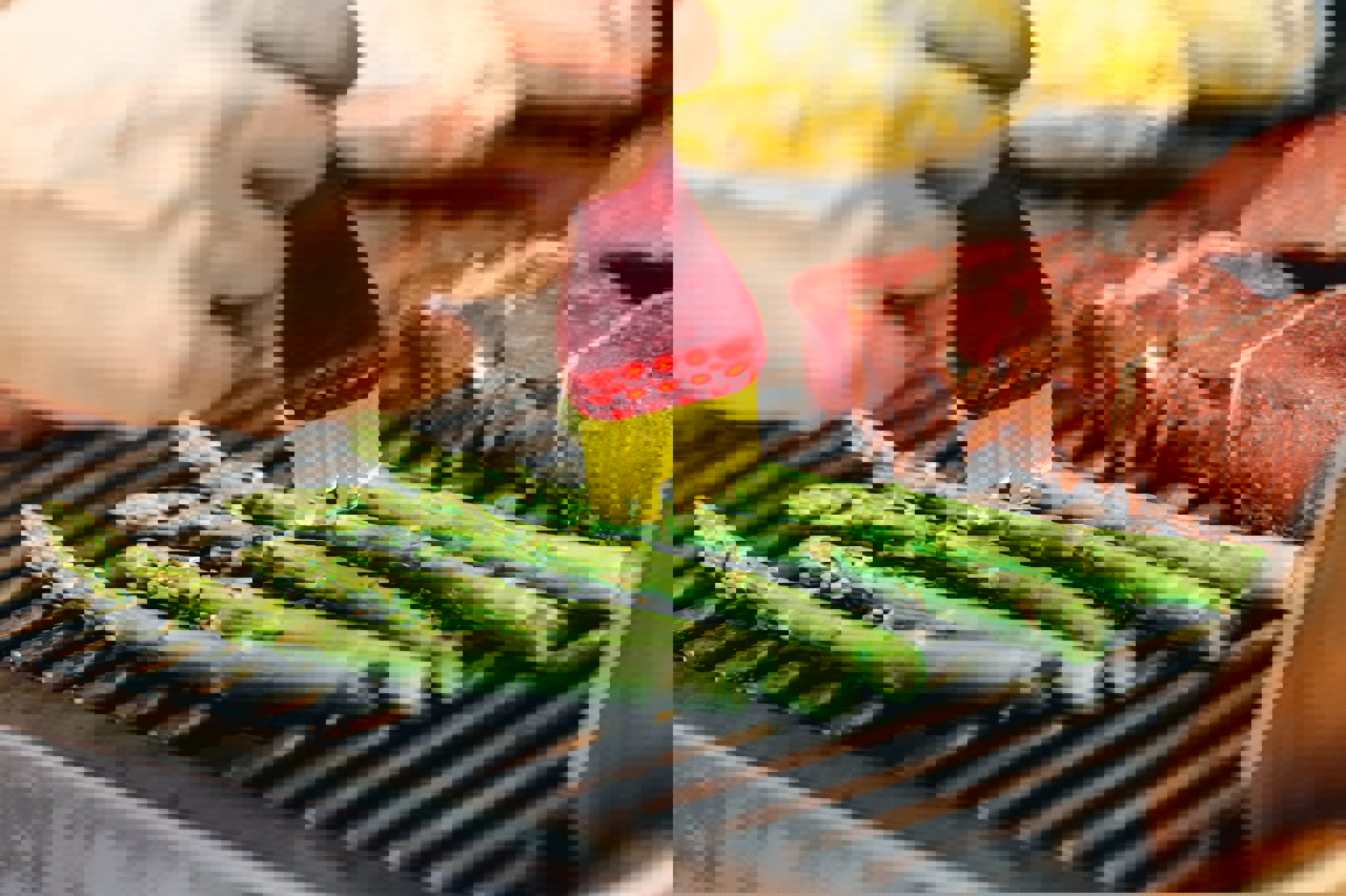 a person is cooking asparagus on a grill