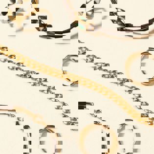 a close up of a bracelet , ring , and necklace on a white surface