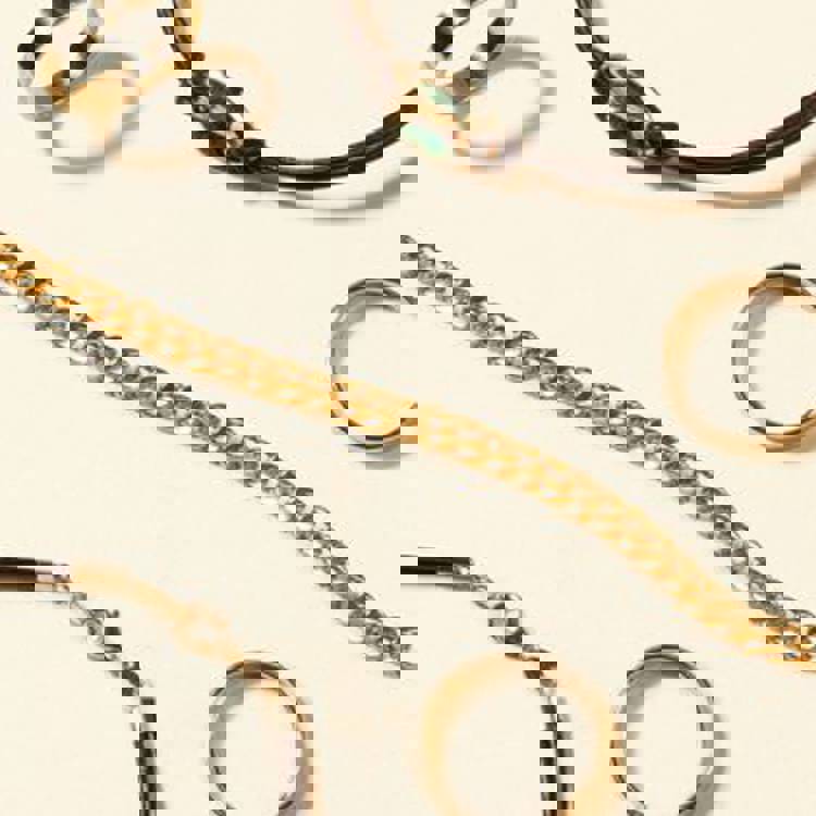 a close up of a bracelet , ring , and necklace on a white surface