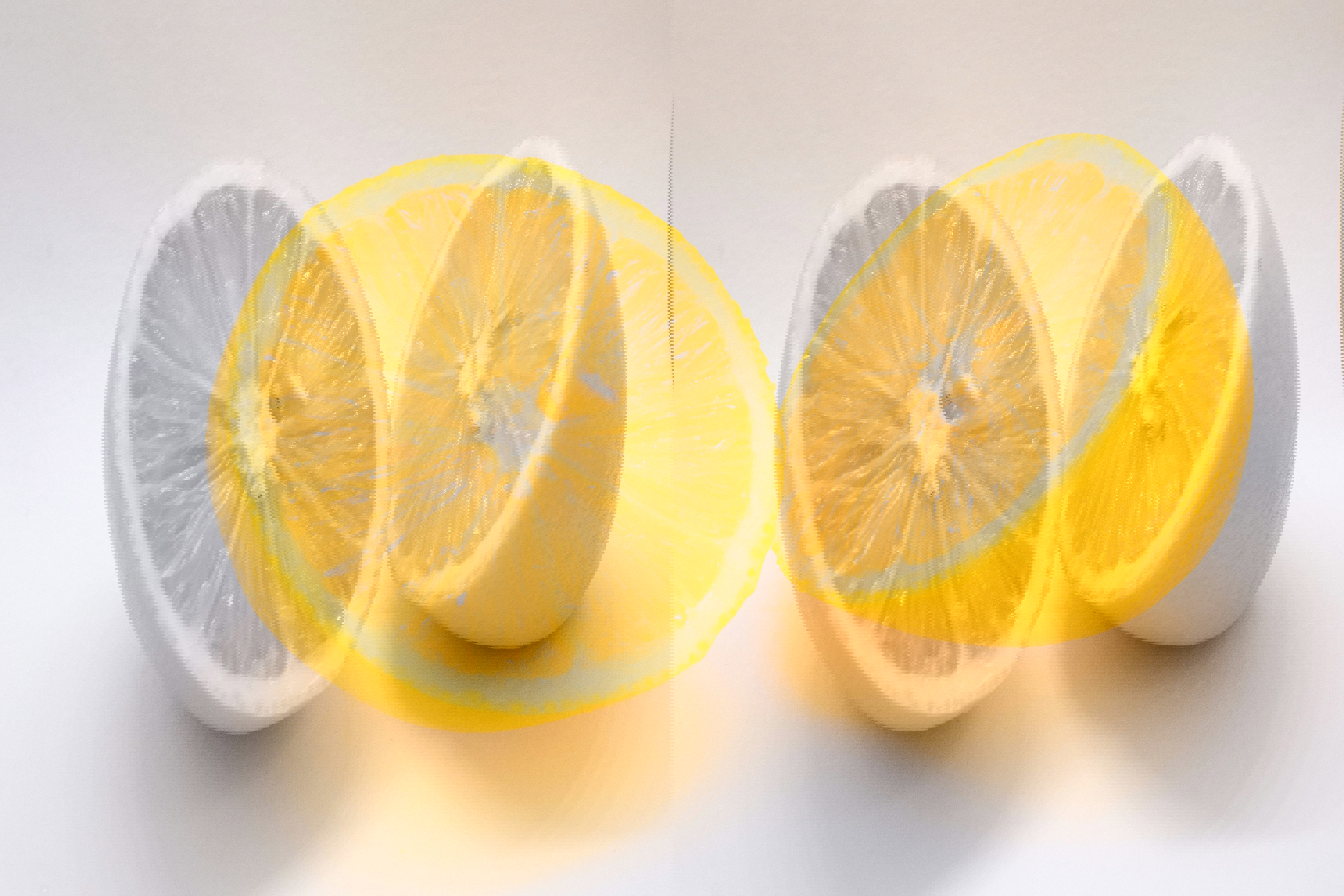 two lemons are cut in half on a white surface