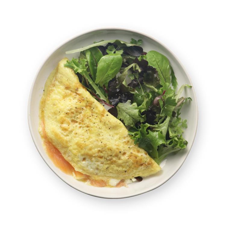 a plate of food with an omelet and a salad on a white background