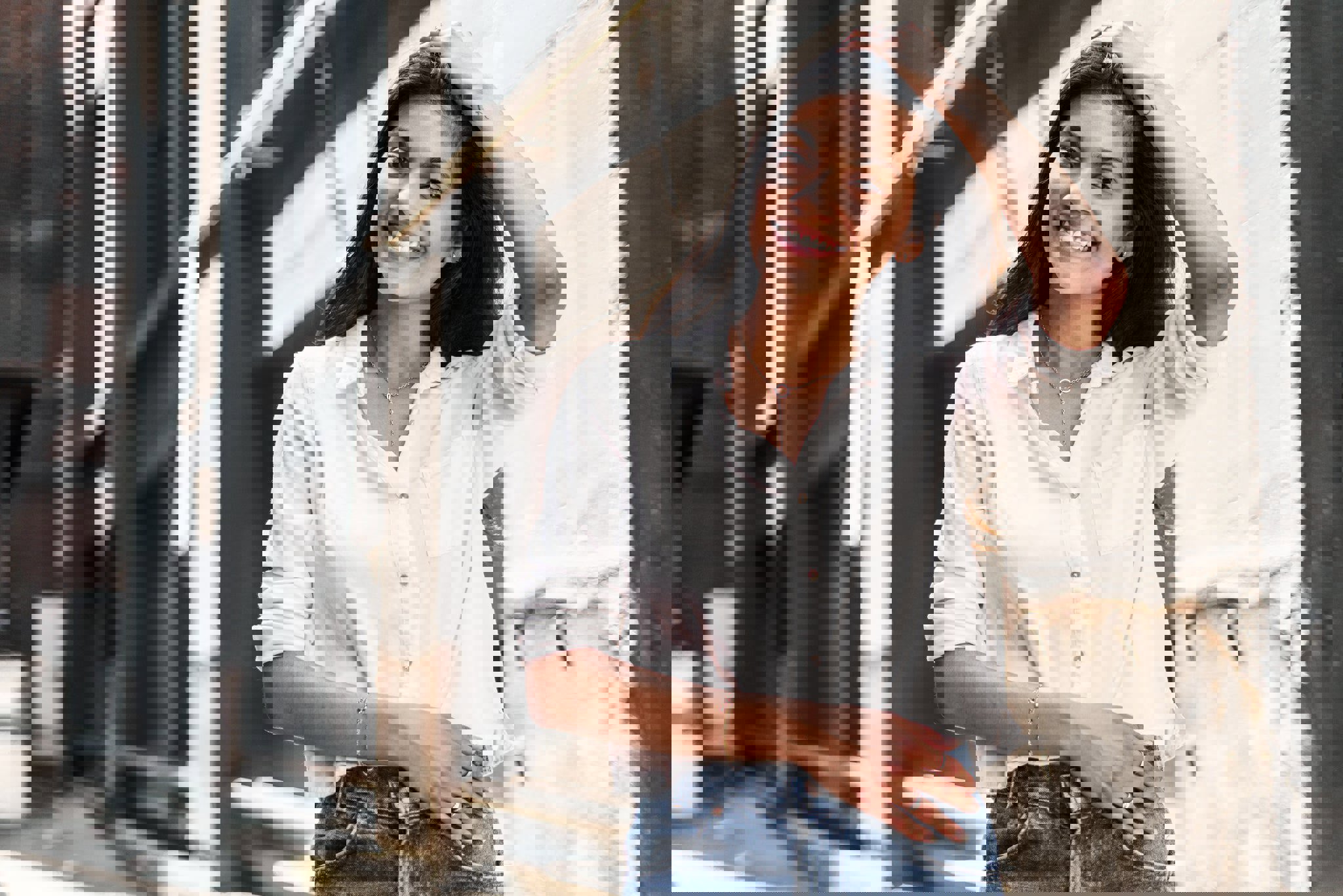 a woman wearing a white shirt and blue jeans is smiling