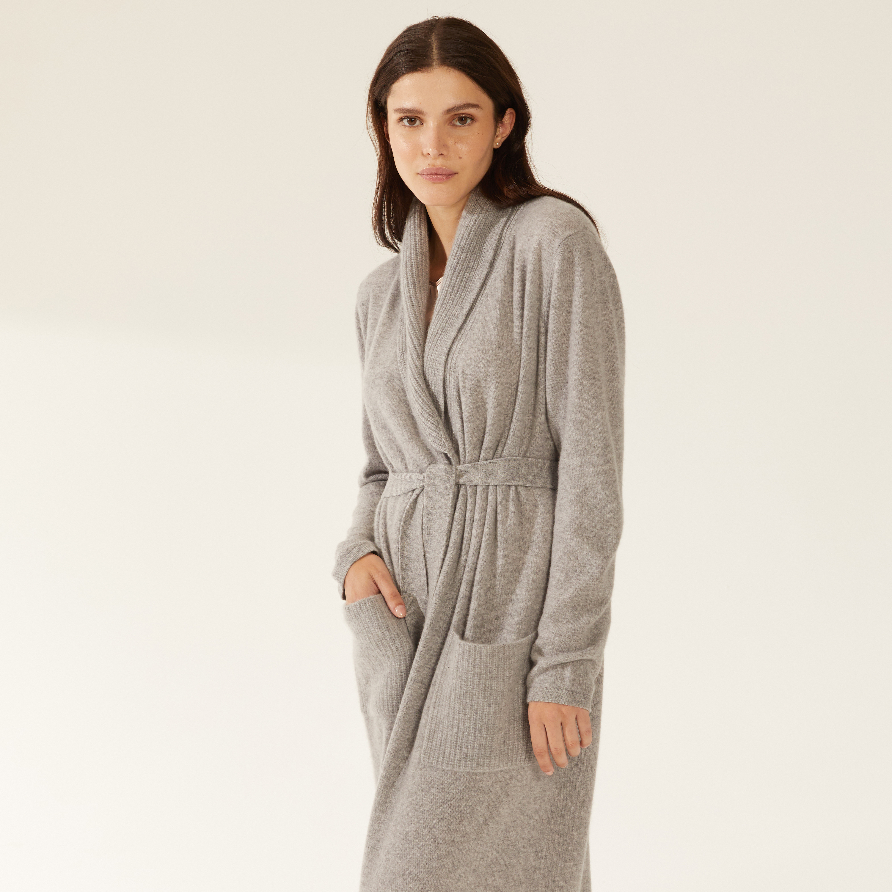 a woman is wearing a grey robe with pockets