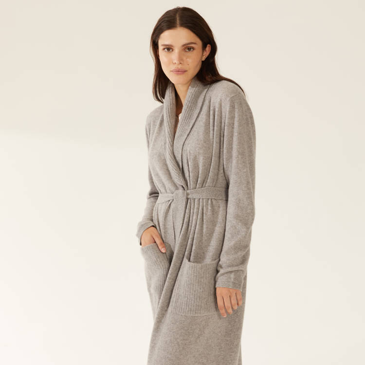 a woman is wearing a grey robe with pockets