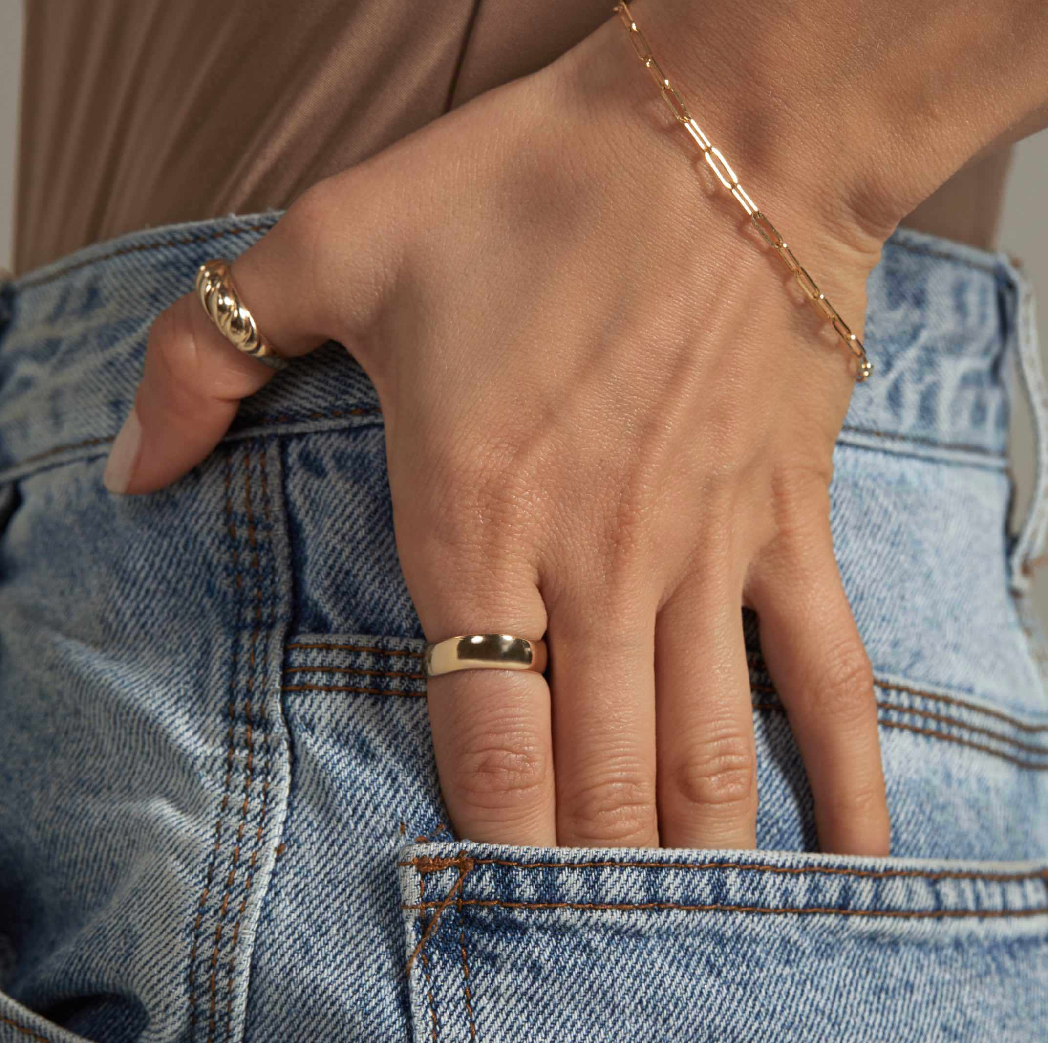 a close up of a person 's hand wearing a ring and a bracelet