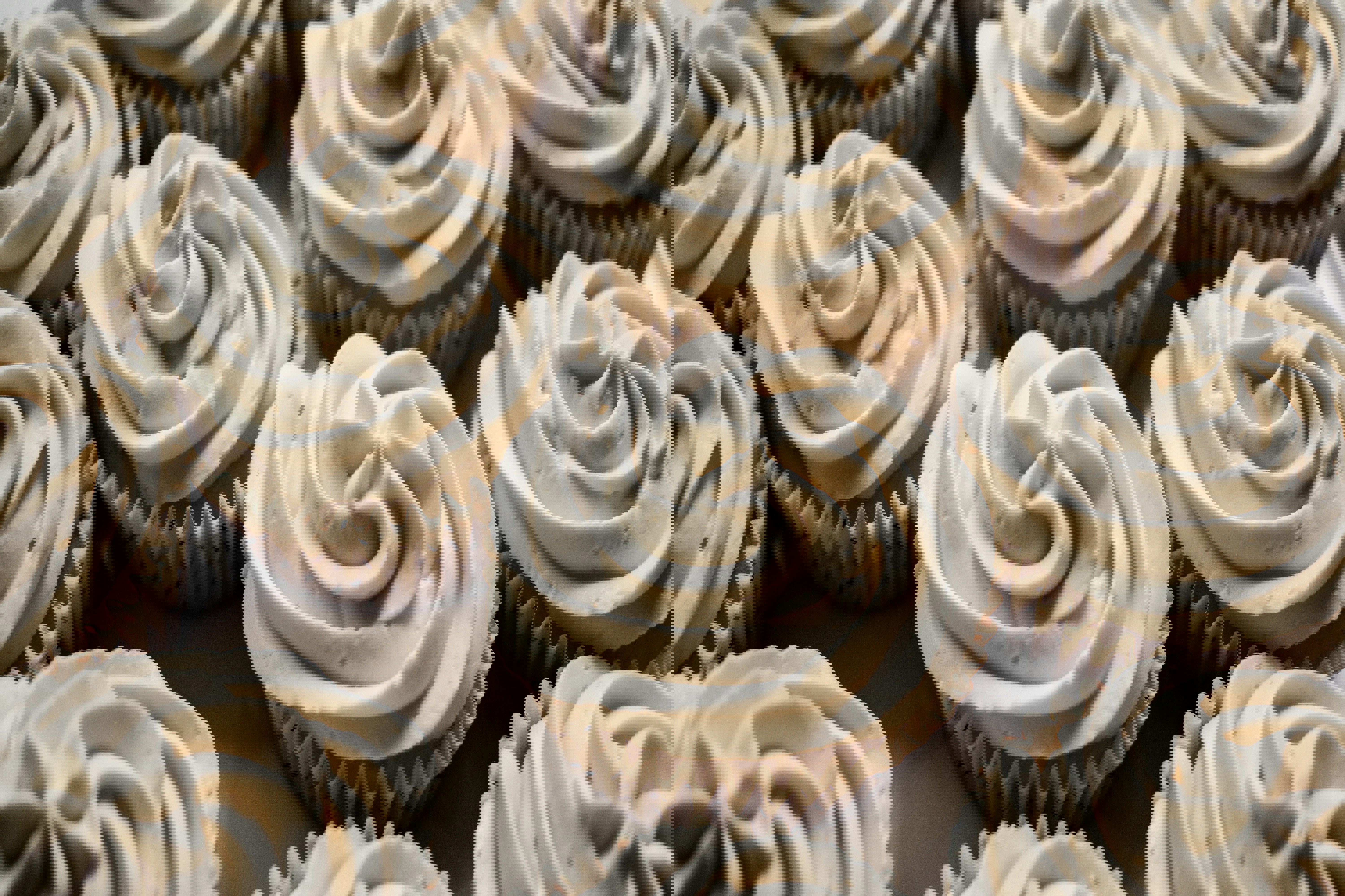 a bunch of cupcakes with white frosting on them