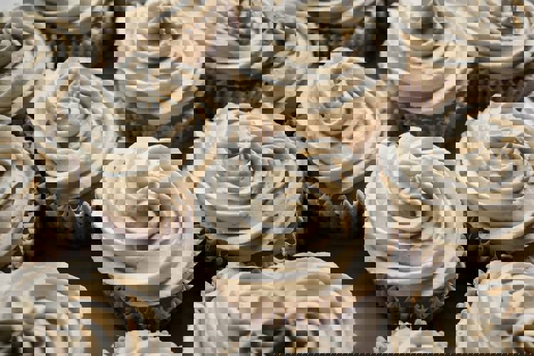 a bunch of cupcakes with white frosting on them