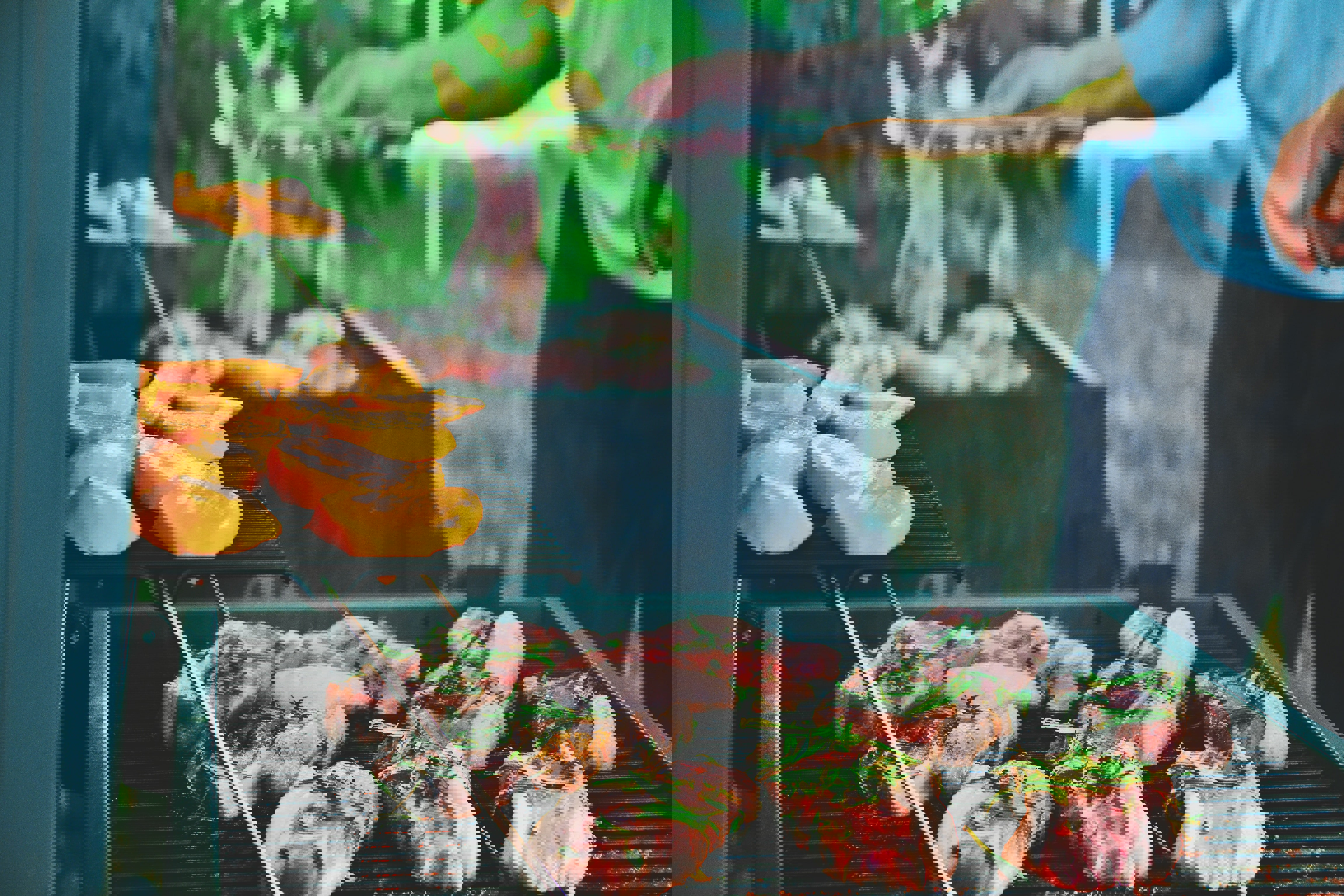 a man is cooking meat and vegetables on a grill