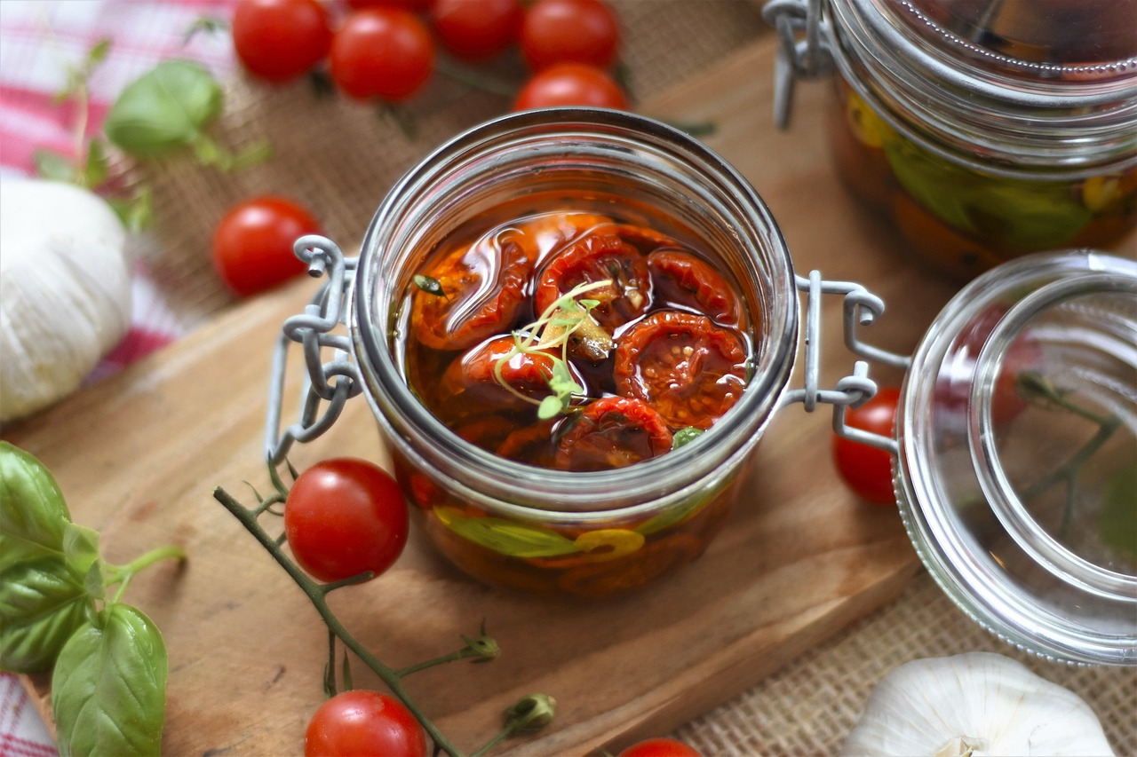 a jar filled with tomatoes is on a cutting board