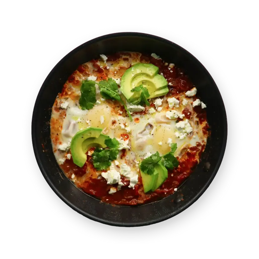 a bowl of food with eggs , avocado , cheese and cilantro on a black background