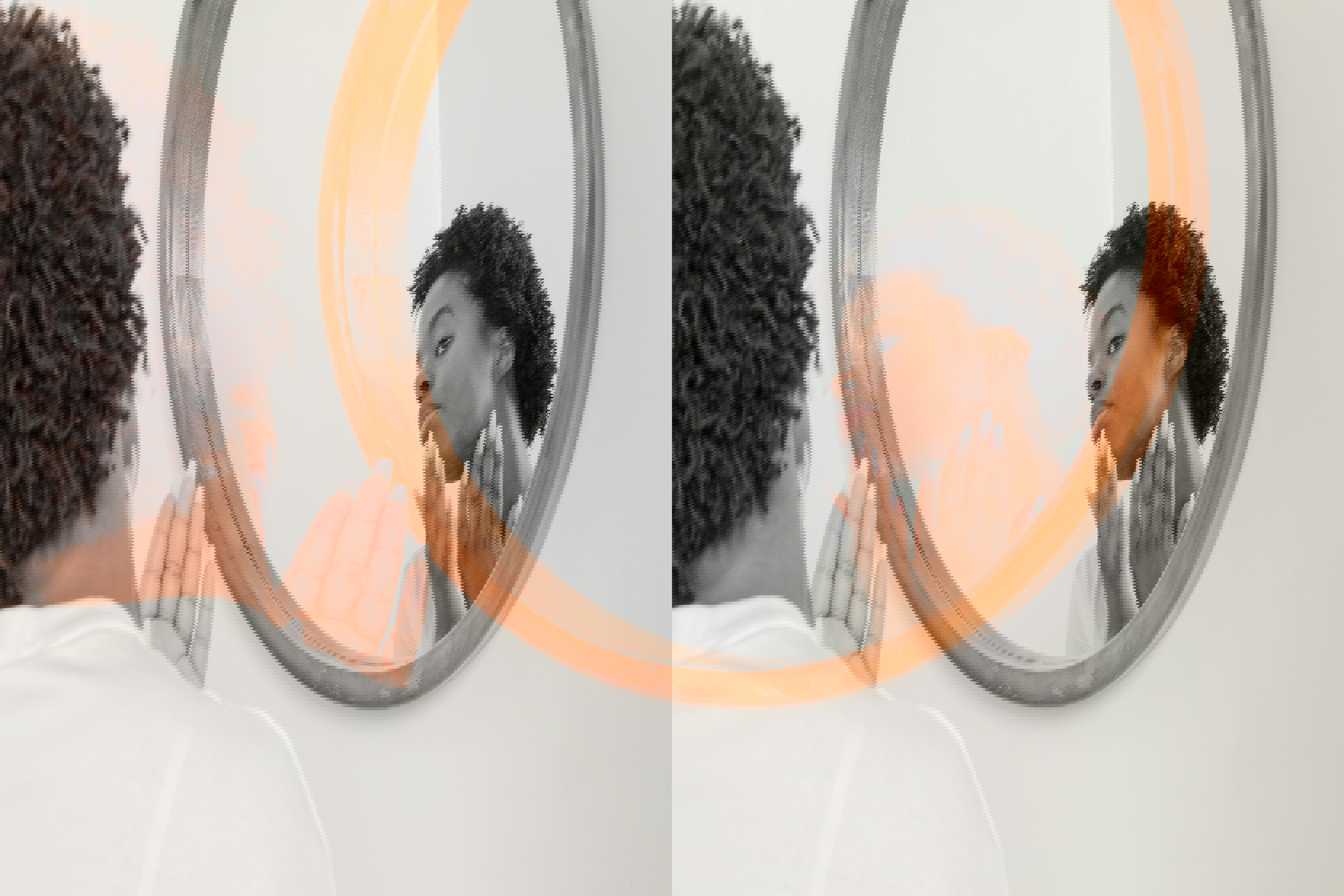 a woman looks at her reflection in a round mirror