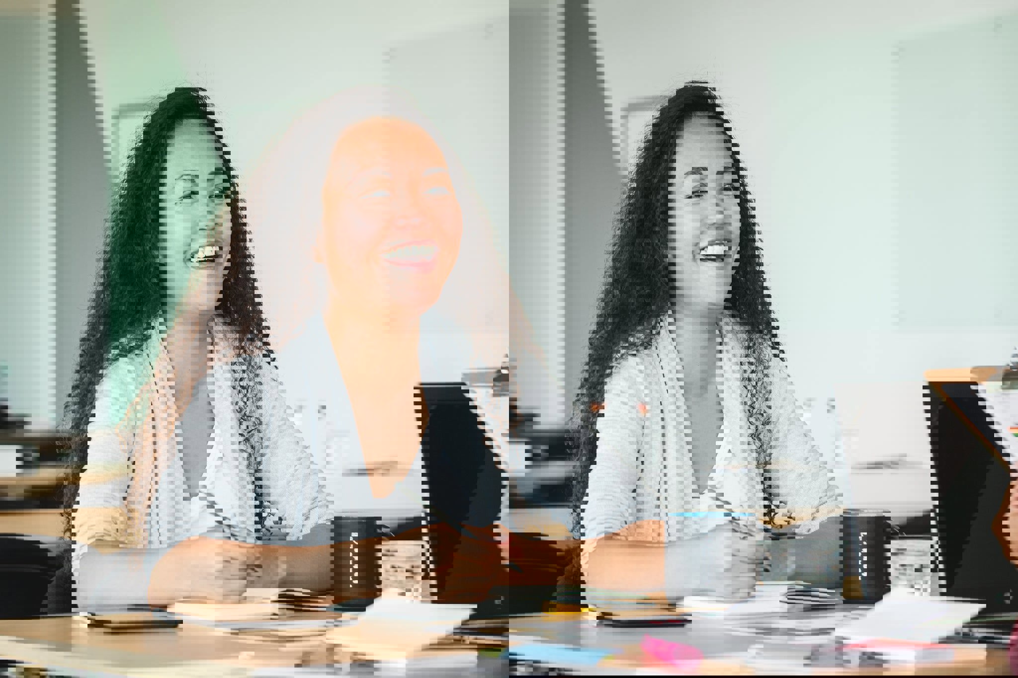 a woman sits at a desk with a mug that says foundation on it