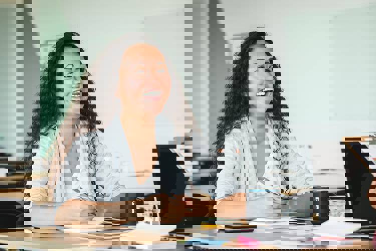 a woman sits at a desk with a mug that says foundation on it