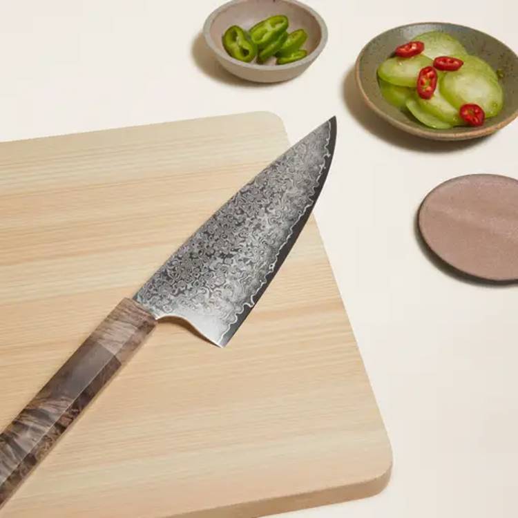 japanese knife on a cutting board with sliced vegetables in bowls