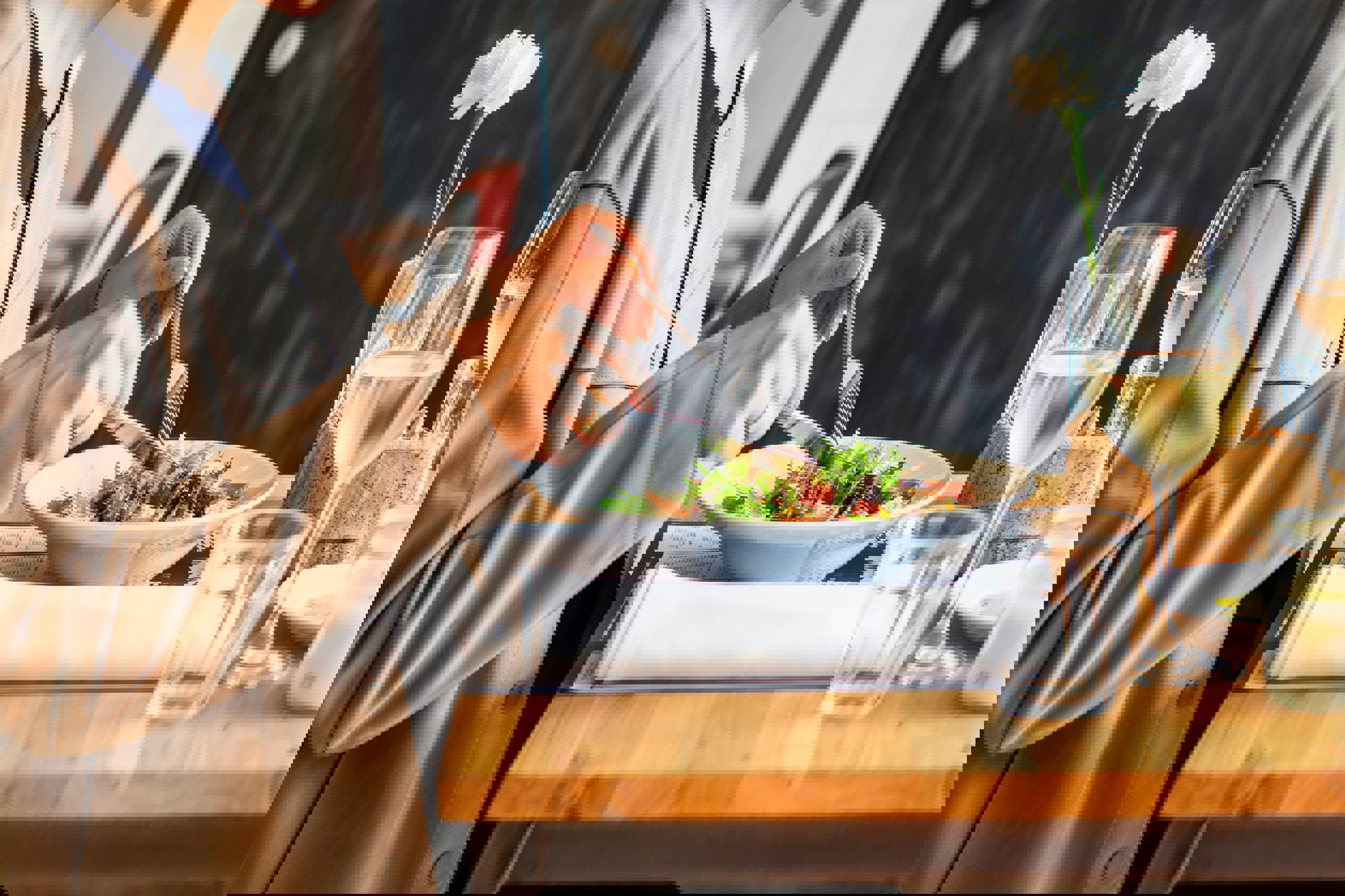 a woman is sitting at a table eating a salad