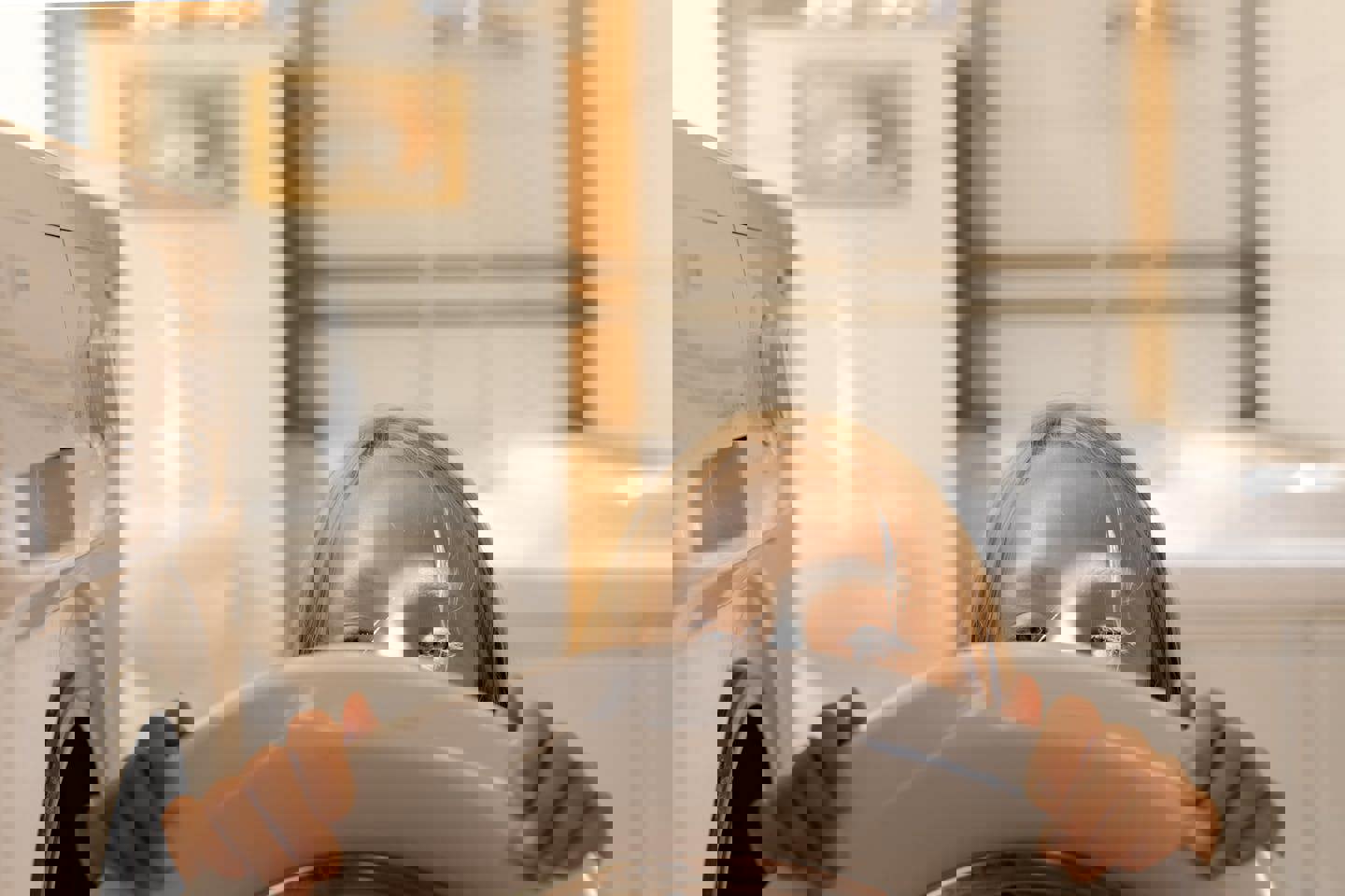 a little girl is peeking out of a washing machine