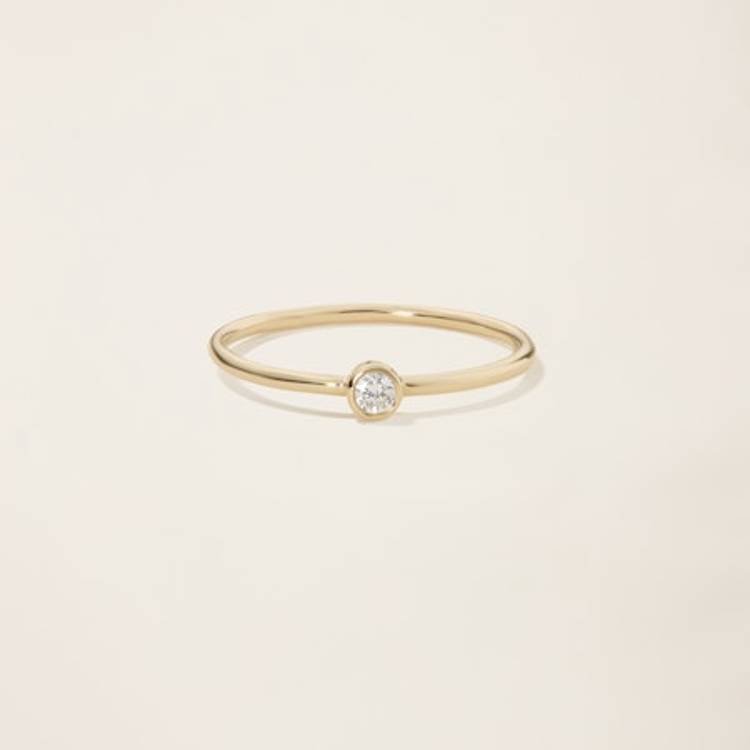 a yellow gold ring with a single diamond in the center