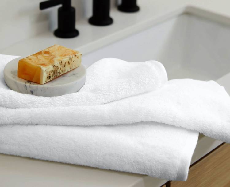 a white towel is sitting on a bathroom sink next to a soap dish