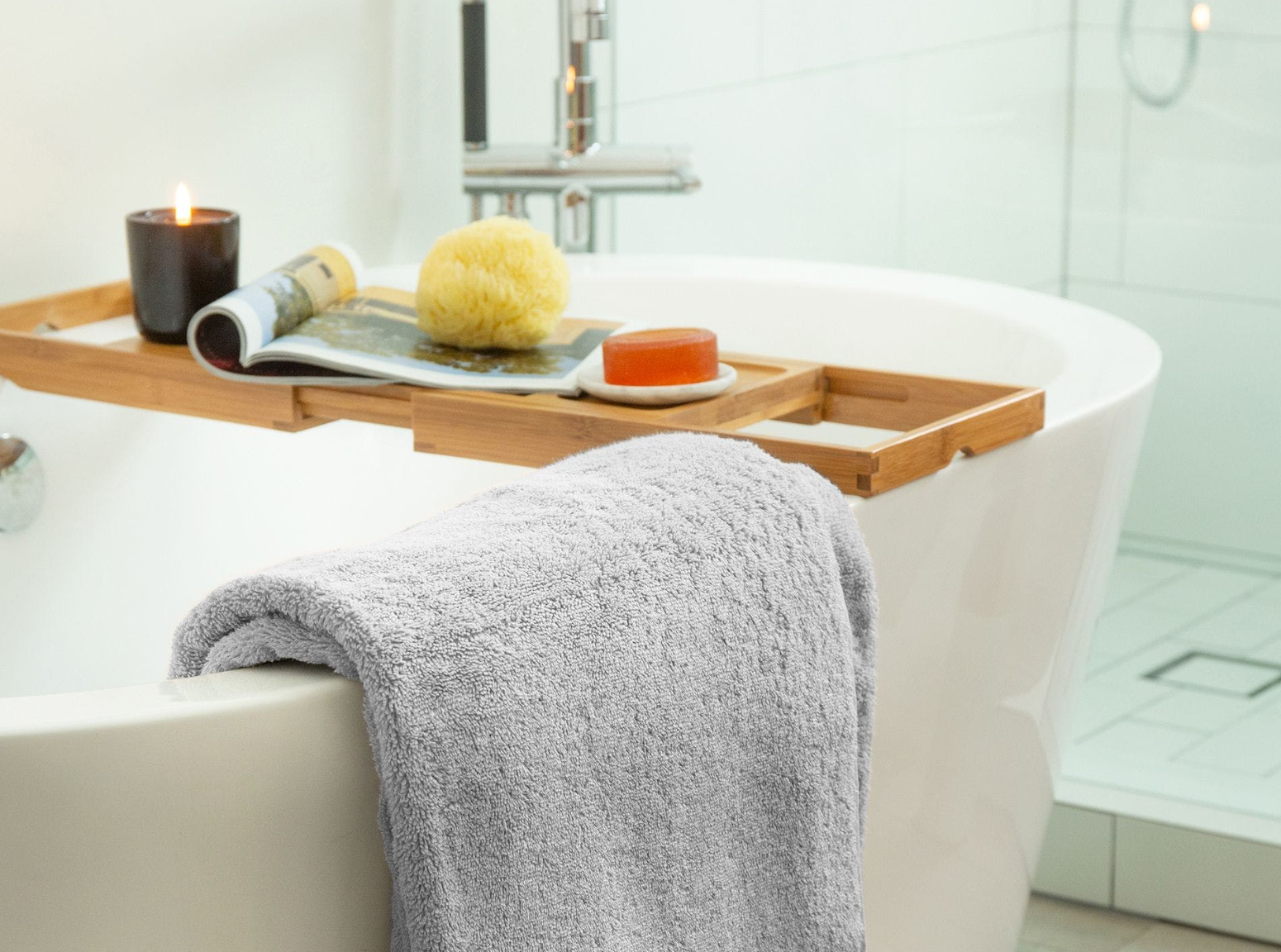 a bathtub with a towel and a candle on it