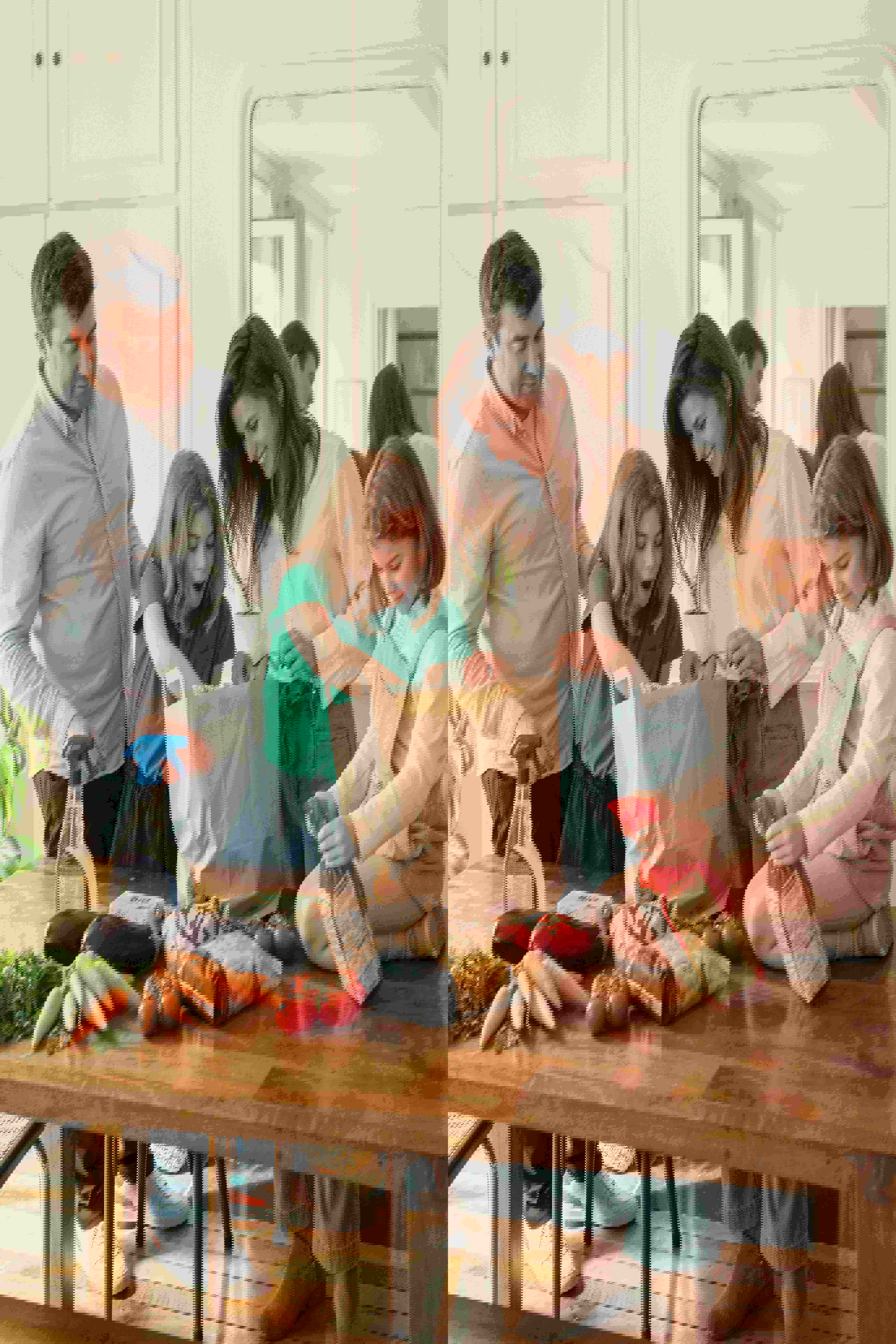 a family is sitting at a table with groceries on it