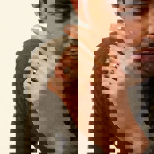 a man is wearing a wedding ring on his left hand