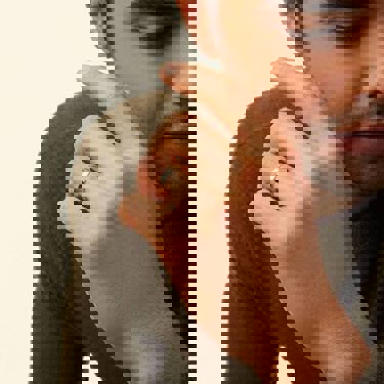 a man is wearing a wedding ring on his left hand