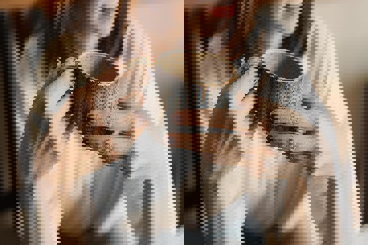 a woman is holding a cup of coffee in her hands