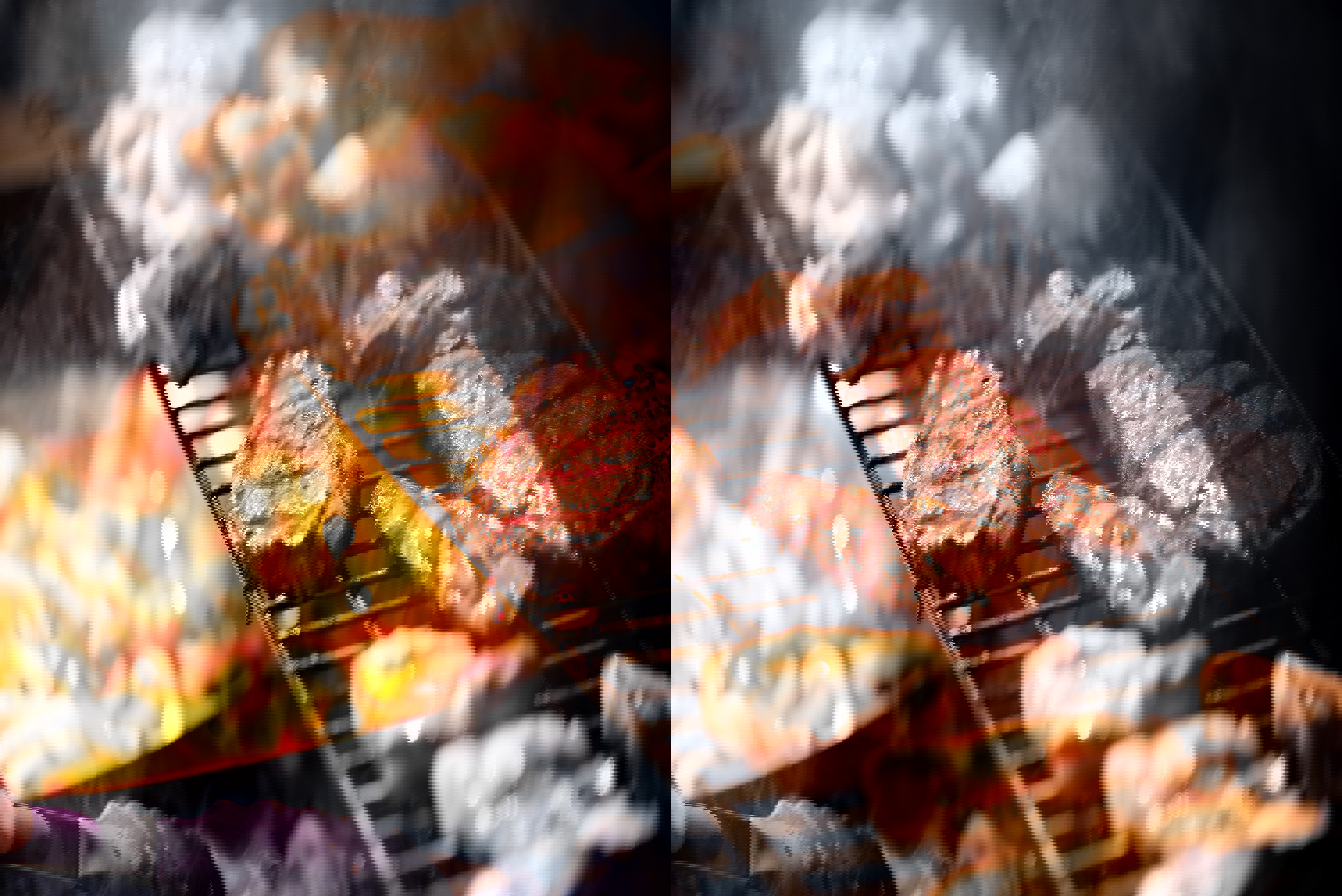 steaks are cooking on a grill with flames in the background