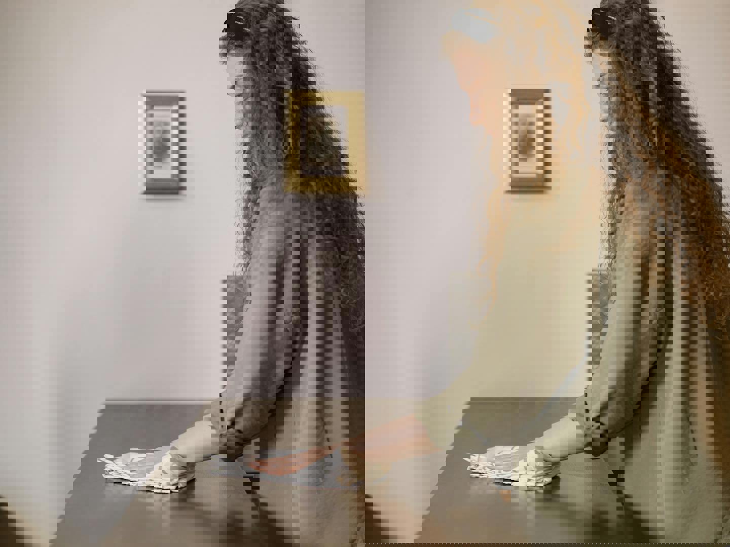 a woman is cleaning a table with a cloth