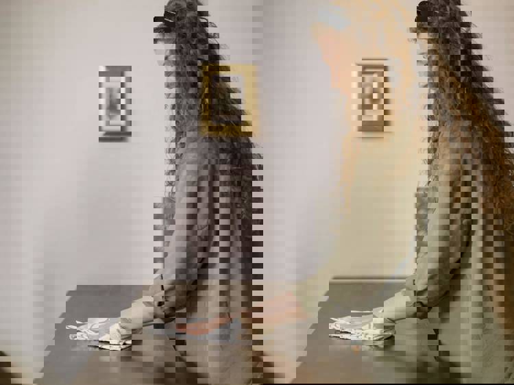 a woman is cleaning a table with a cloth