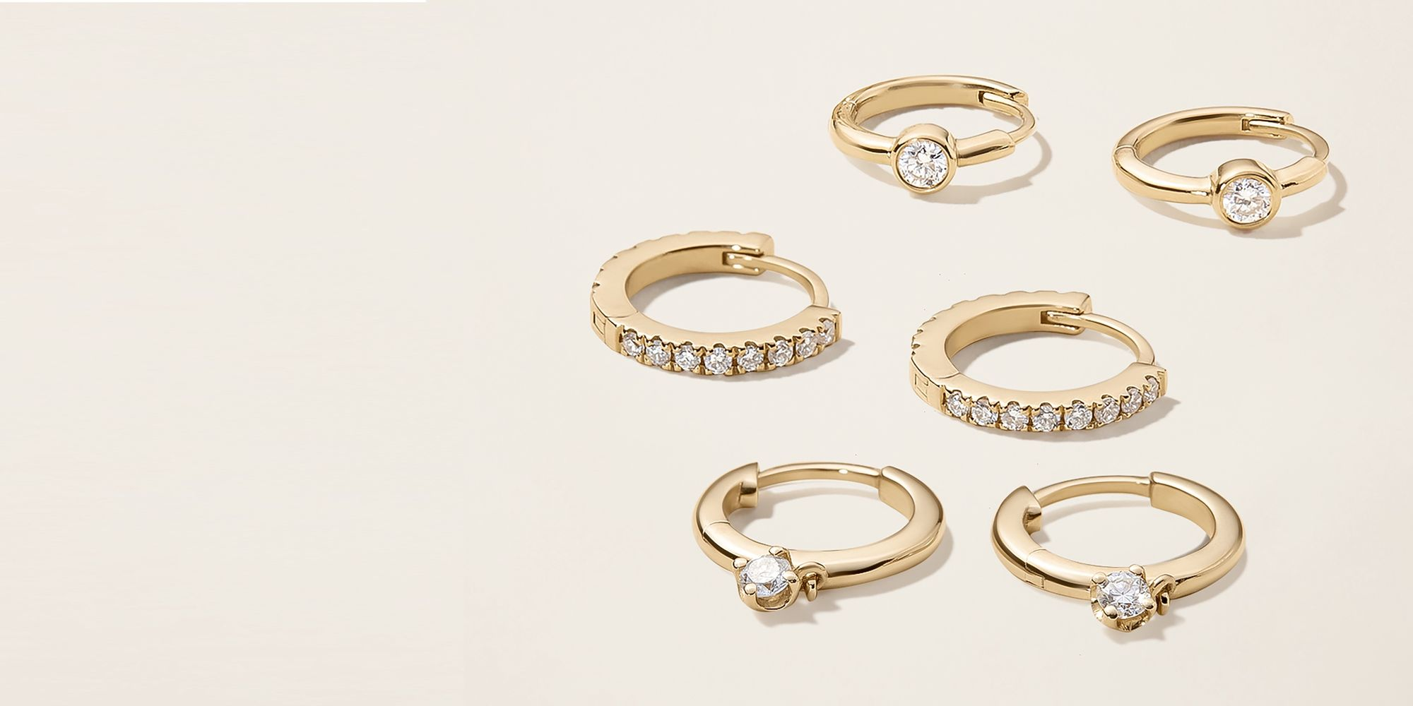 a group of gold hoop earrings with diamonds on them