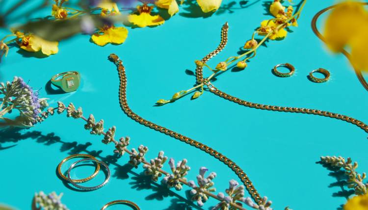 a necklace and rings are on a blue surface