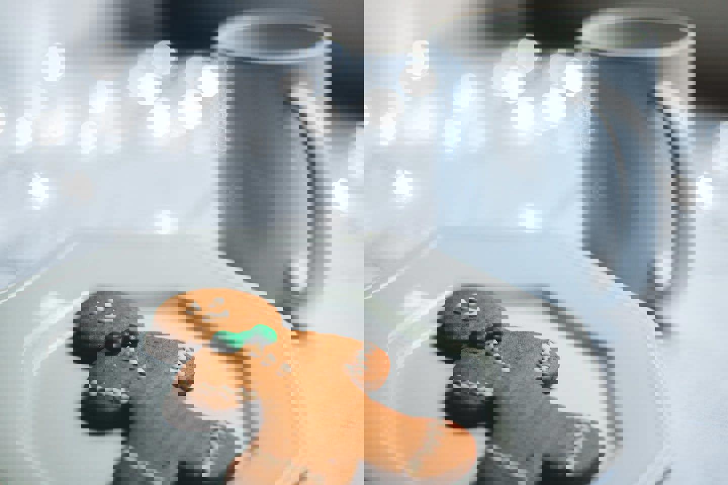 a gingerbread man cookie on a plate next to a cup of coffee