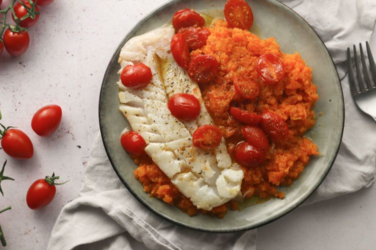 a plate of food with fish and tomatoes on it