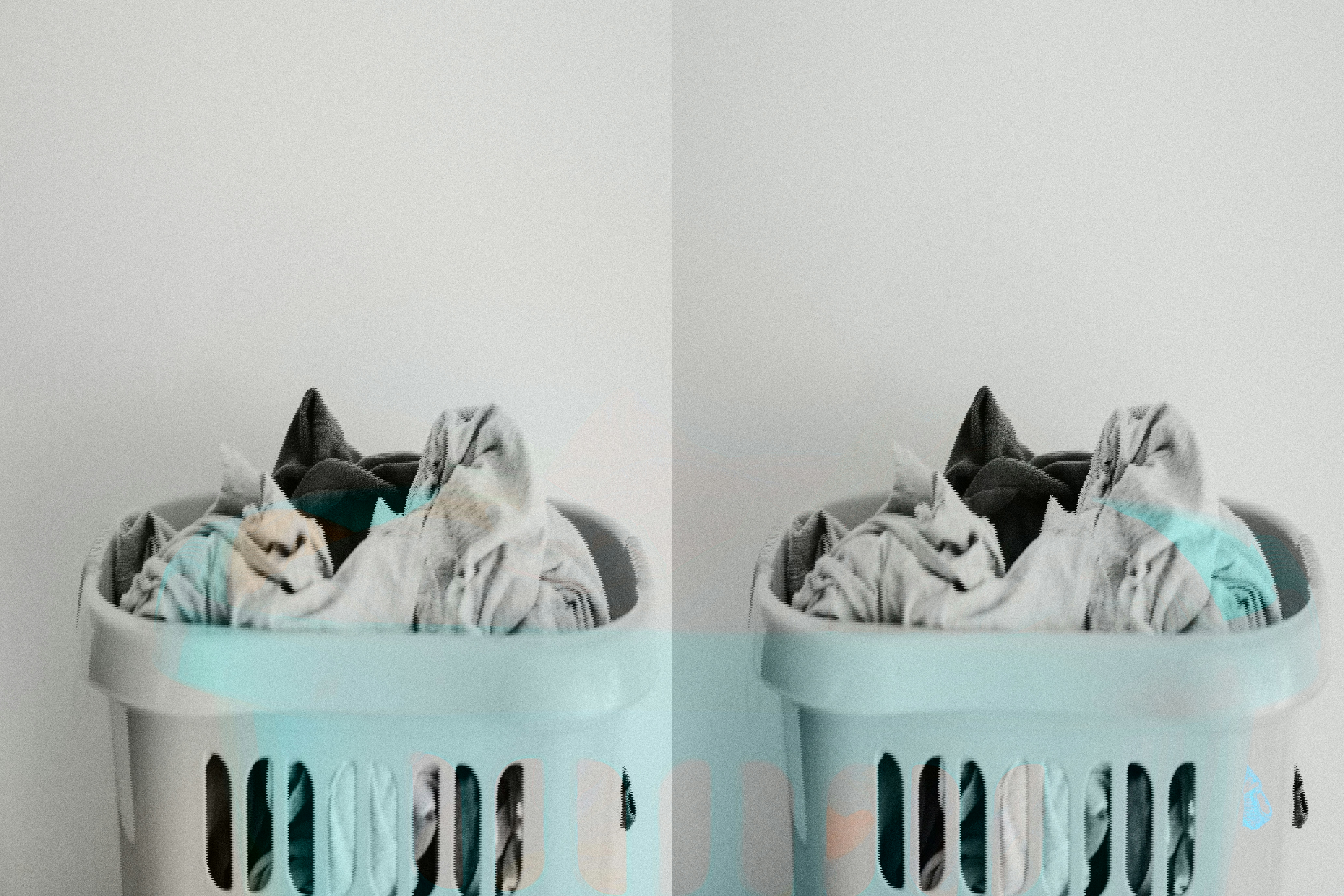 a blue laundry basket filled with clothes against a white wall